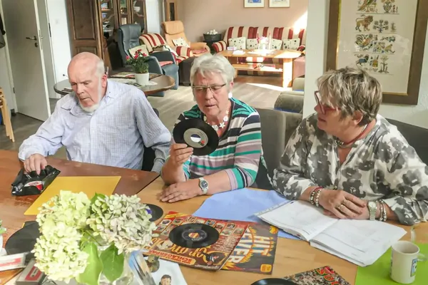 Bewohner*innen und Pflegekraft mit alten Schallplatten